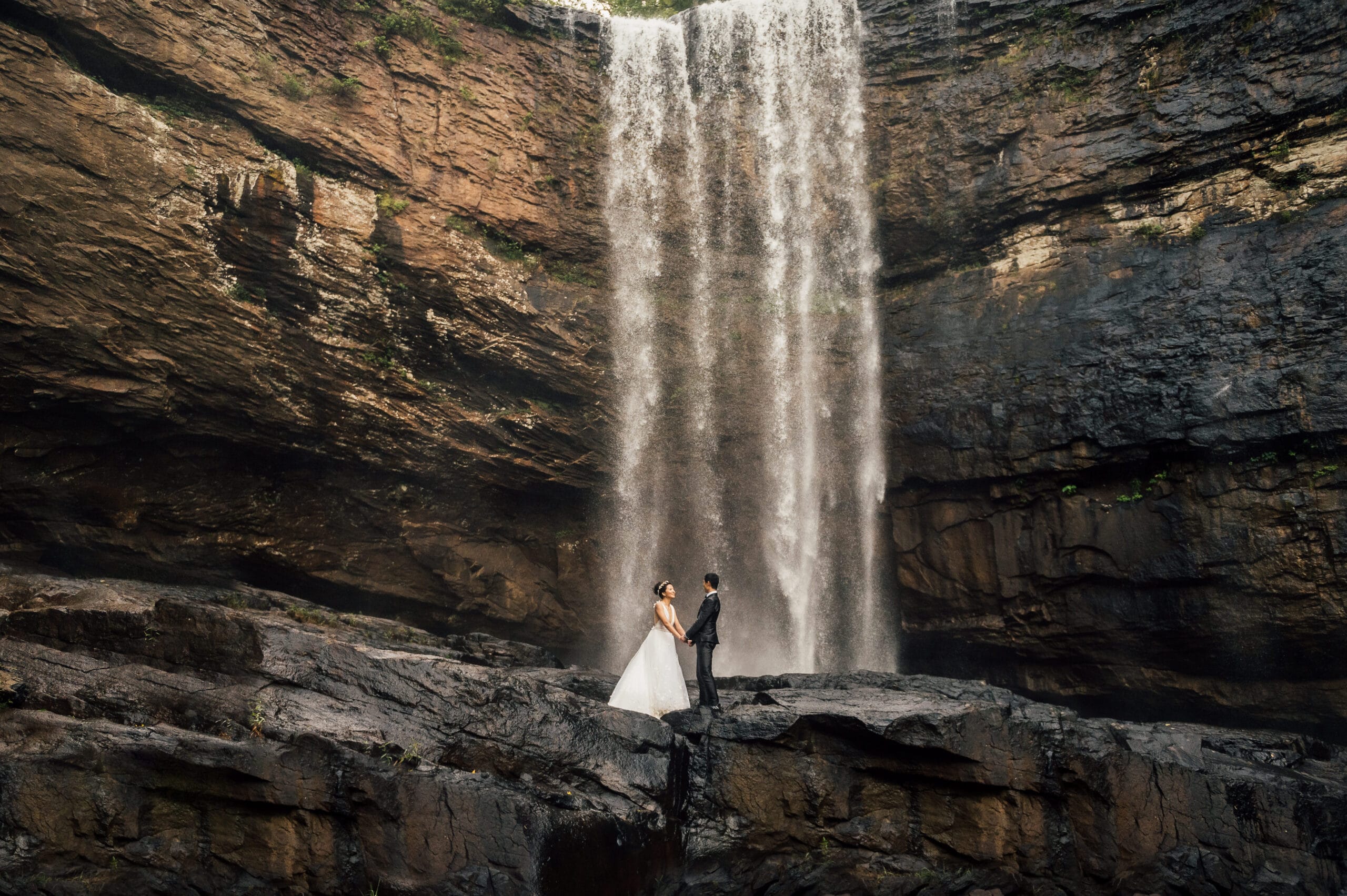 A couple who decide to elope in Tennessee stand in front of a Chattanooga waterfall