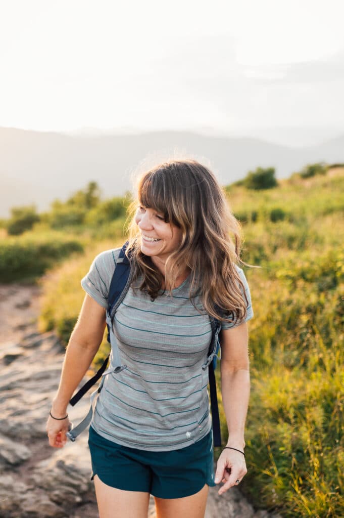 girl in striped shirt hiking at sunset