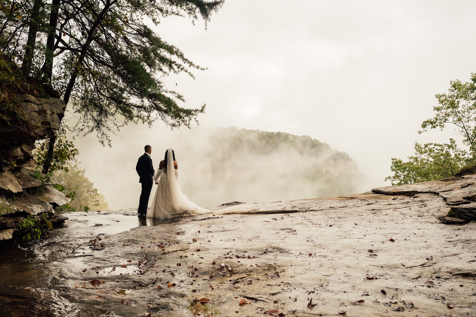 Couple stands on overlook with fog during Tennessee Elopement